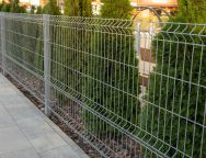 A,Metal,Mesh,Fence,Encloses,A,Private,Area.,Thuja,Hedge